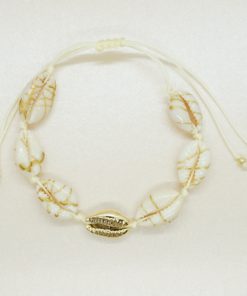 Muschel-Armband mit Kauri-Muscheln gesprenkelt und goldener Kauri-Muschel auf beigen Band.